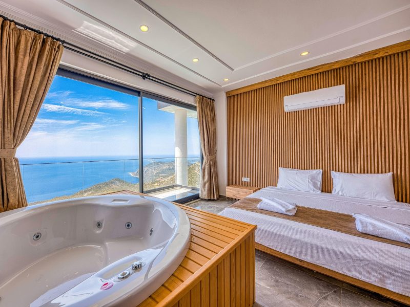 Habitación con cama, jacuzzi y vista al mar